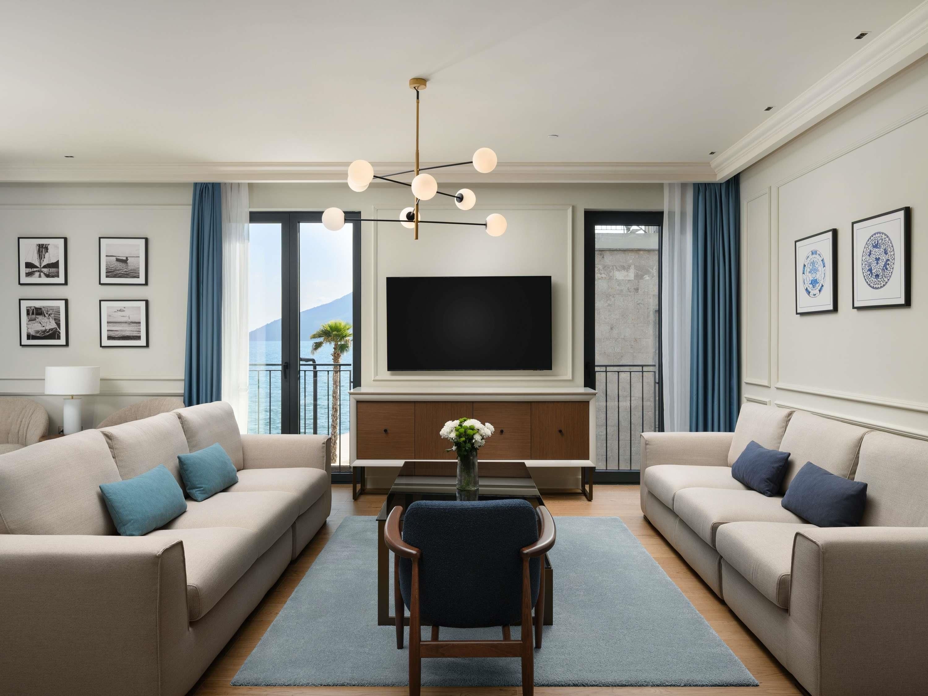 Een moderne woonkamer met twee banken, een salontafel en een televisie aan een wand.