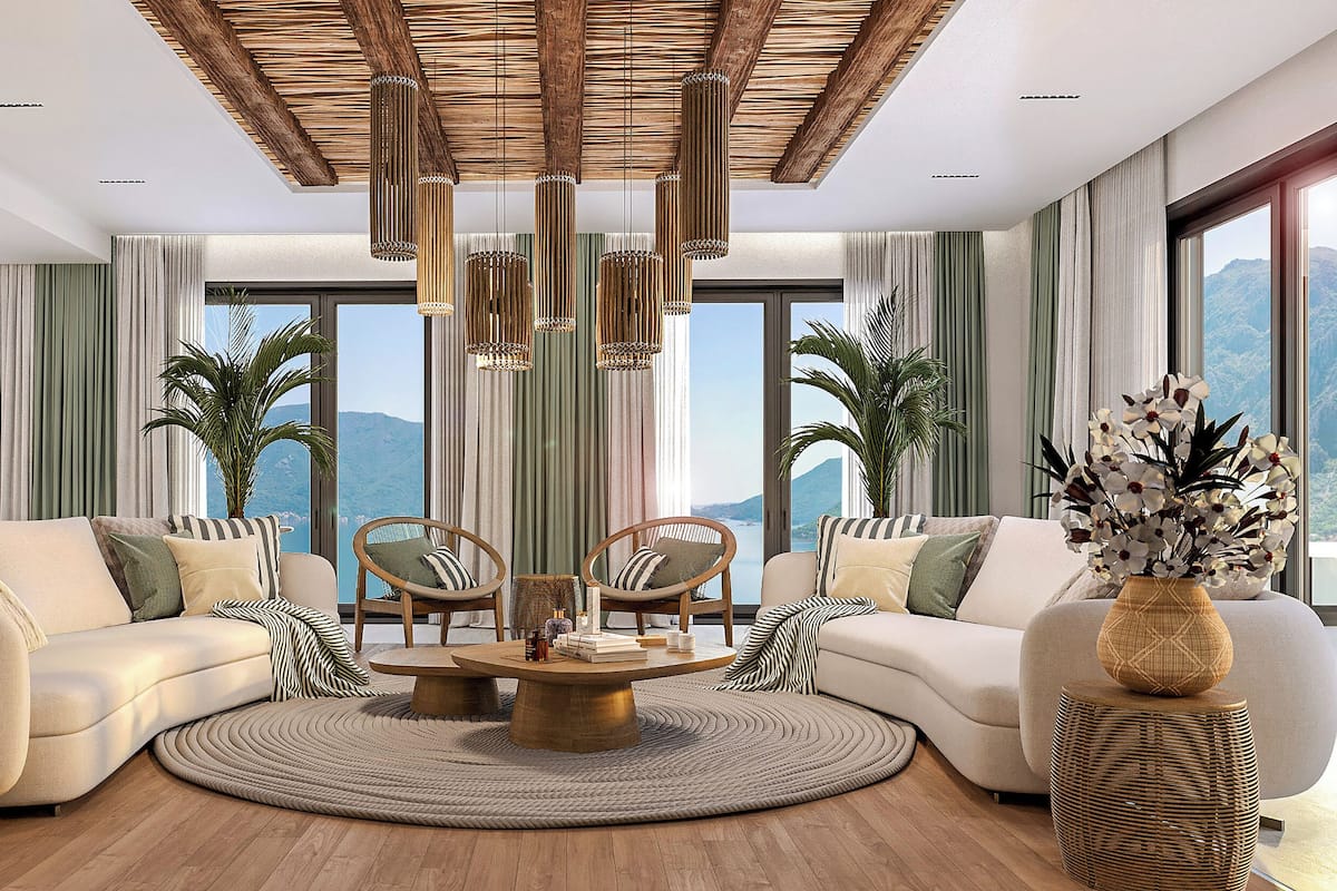 A modern living room with a round coffee table, two sofas, and a view of mountains through large windows.