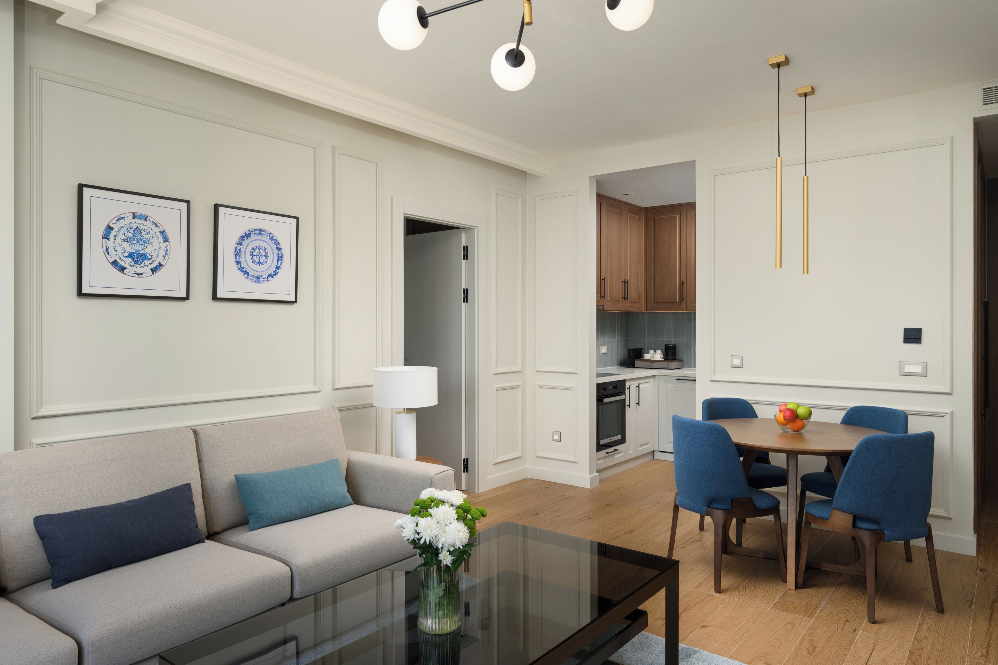 Una sala de estar moderna con un sofá, una mesa de centro de vidrio y un comedor con sillas y una mesa.