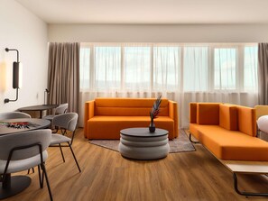 A modern living room with a sofa, chairs, a coffee table, and a lamp. - Novotel Zagreb - opened September 2025 (Zagreb)