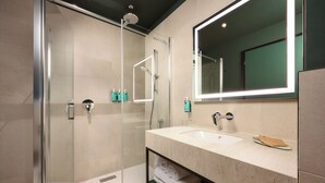 A modern bathroom with a glass-enclosed shower, a large mirror, and a vanity with a sink and towel rack. - Novotel Zagreb - opened September 2025 (Zagreb)