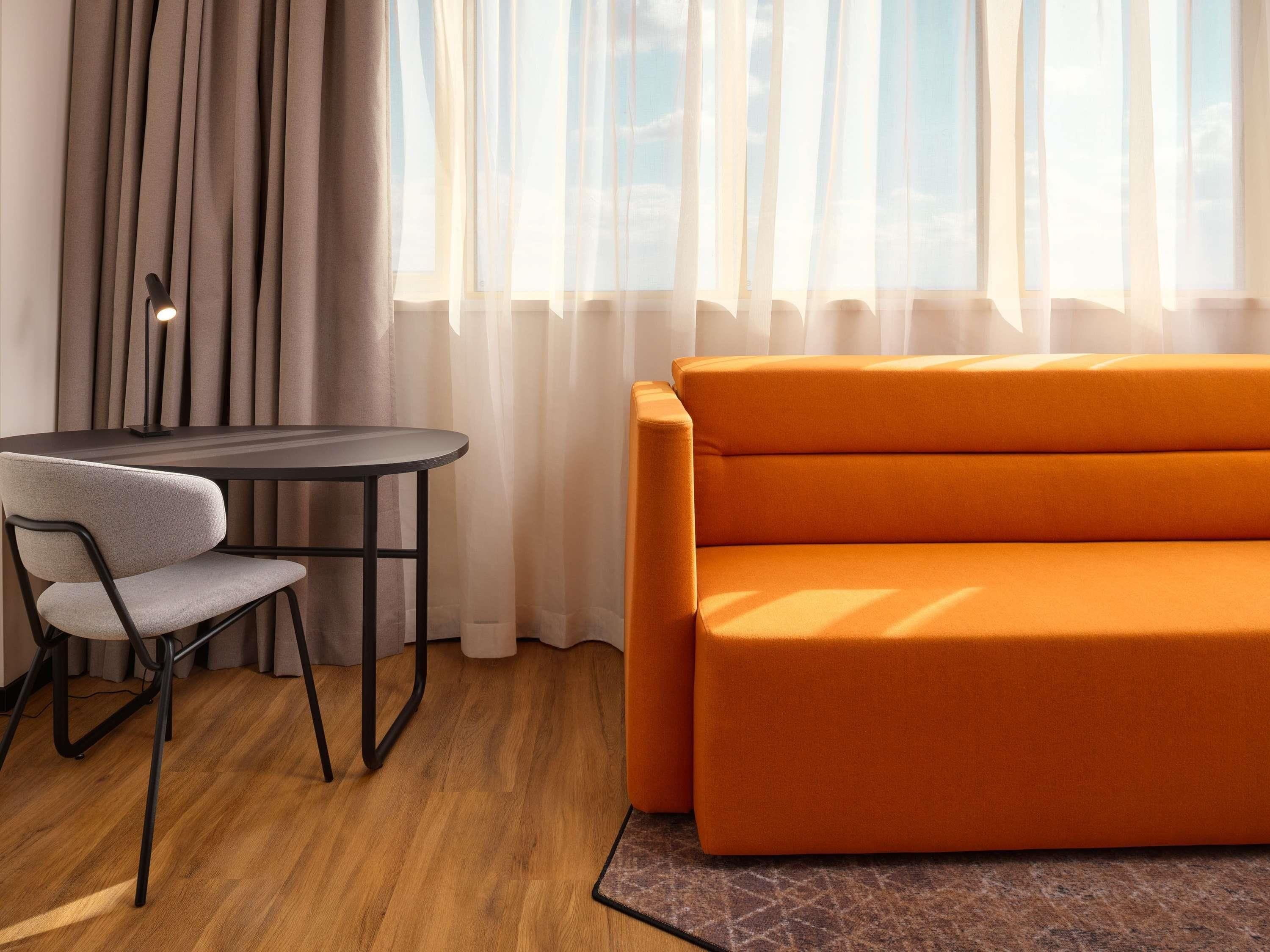 A modern room with a round table and a sofa.