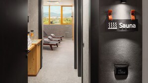A modern spa area with a sauna sign, wooden massage tables, and a view of the outdoors. - Novotel Zagreb - opened September 2025 (Zagreb)