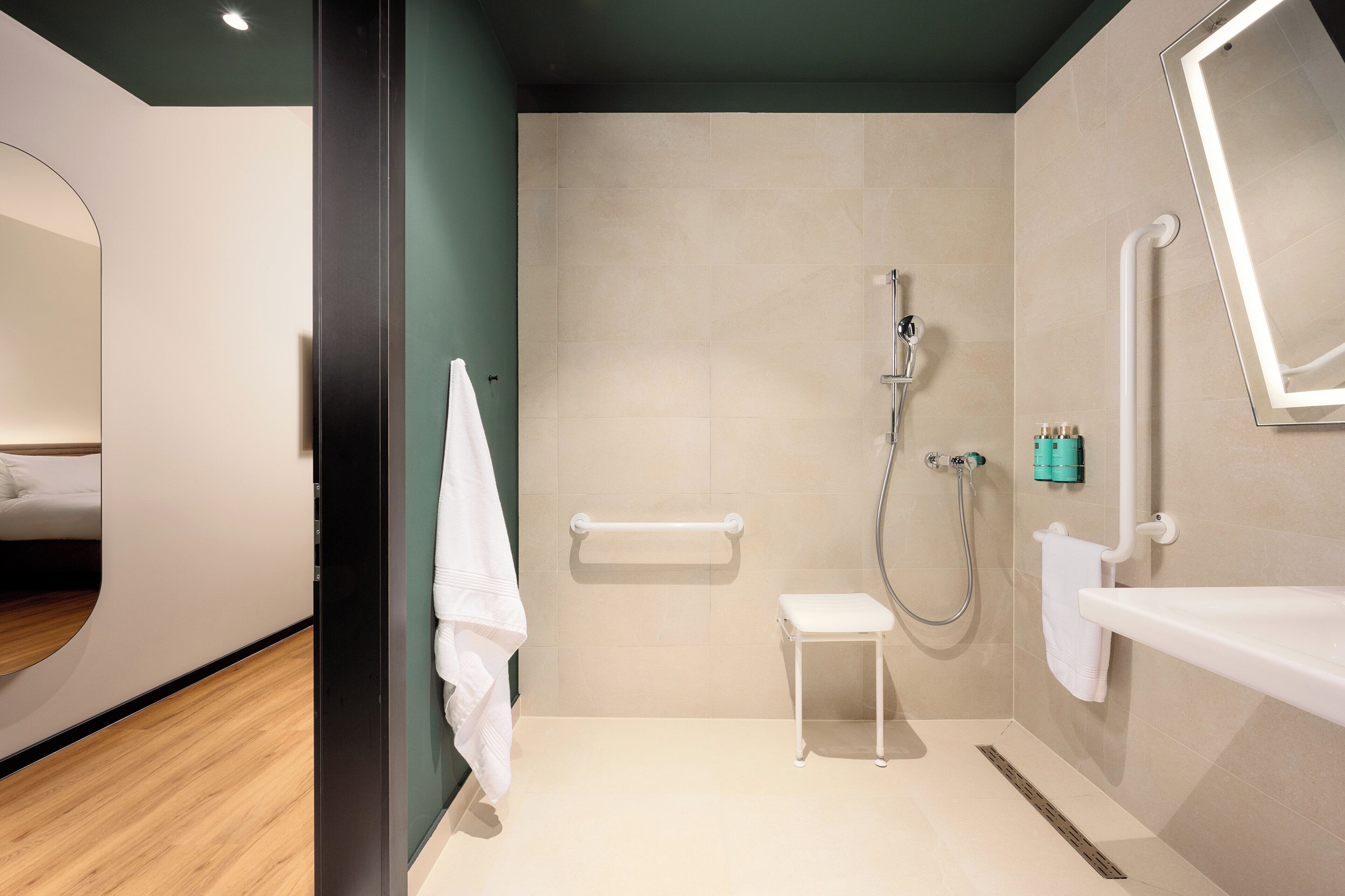 Une salle de bain moderne avec une douche, un lavabo et un miroir.