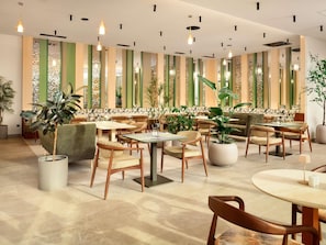A modern interior with multiple seating areas, including sofas and tables, and decorative plants. - Novotel Zagreb - opened September 2025 (Zagreb)
