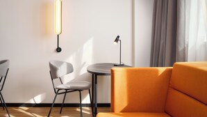 A modern living room with a sofa, two chairs, a small round table, and a lamp. - Novotel Zagreb - opened September 2025 (Zagreb)