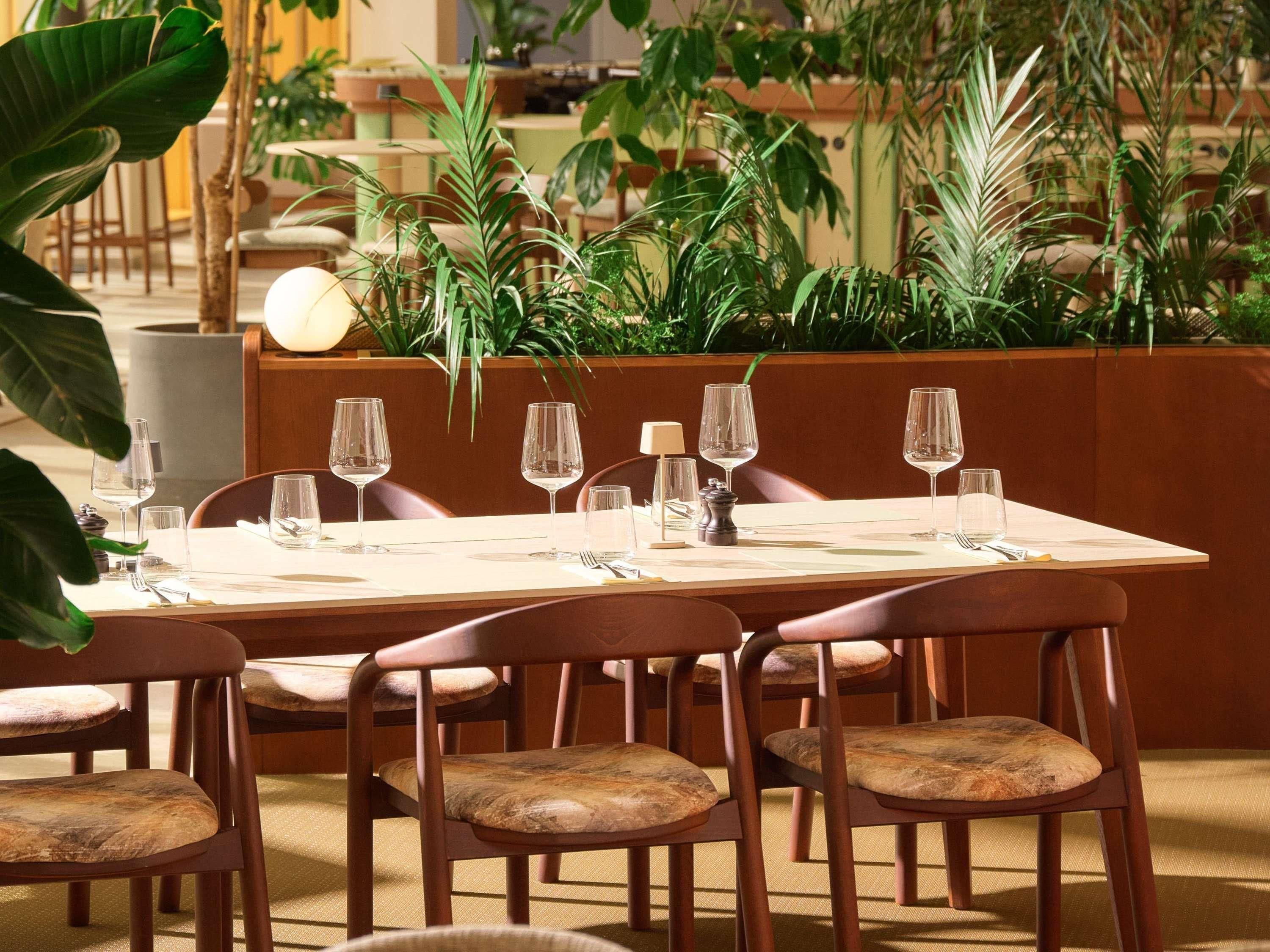 A dining area with a table set for six, surrounded by chairs with cushioned seats.