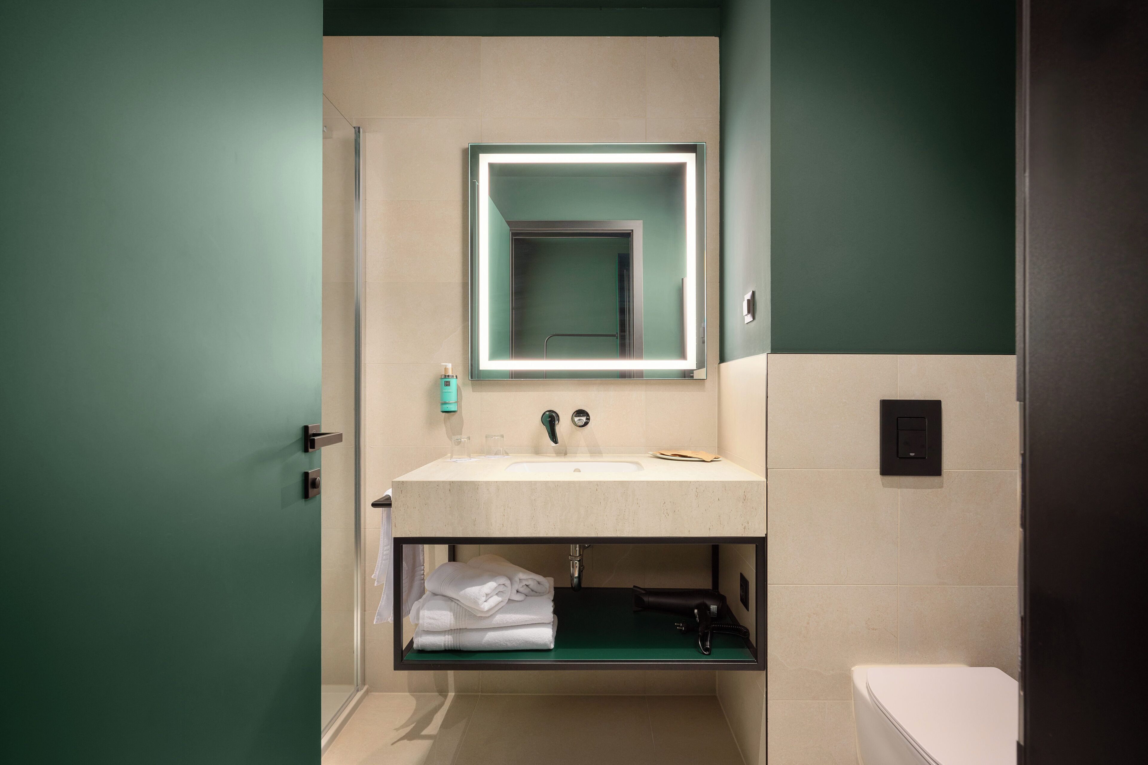 A bathroom with a sink, mirror, and toilet.