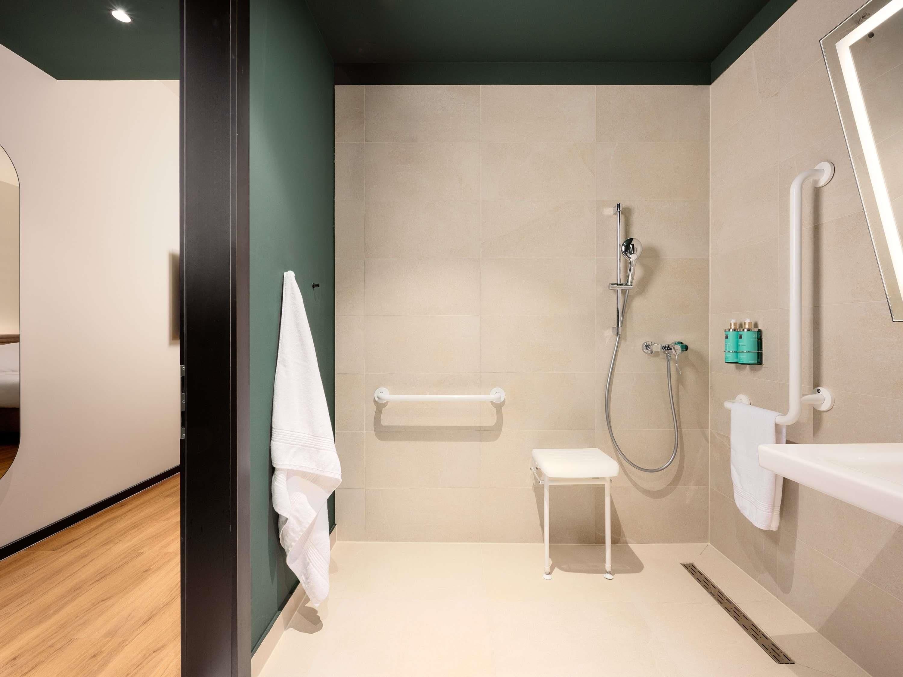 A modern bathroom with a shower, a toilet, a sink, and a towel rack.