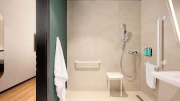 Un baño moderno con ducha, inodoro, lavabo y toallero.