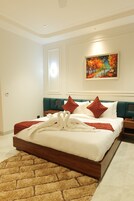 Una habitación de hotel moderna con una cama grande, cabecera color aguamarina y un cuadro colorido en la pared.