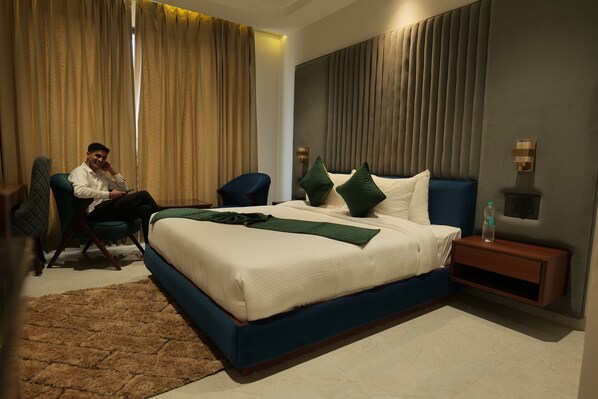 Una habitación de hotel moderna con una cama grande, un escritorio y una silla.