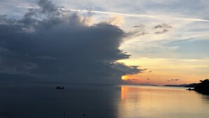 A calm body of water with a boat and a distant shoreline. - Incekum Pansiyon (Maziköy)