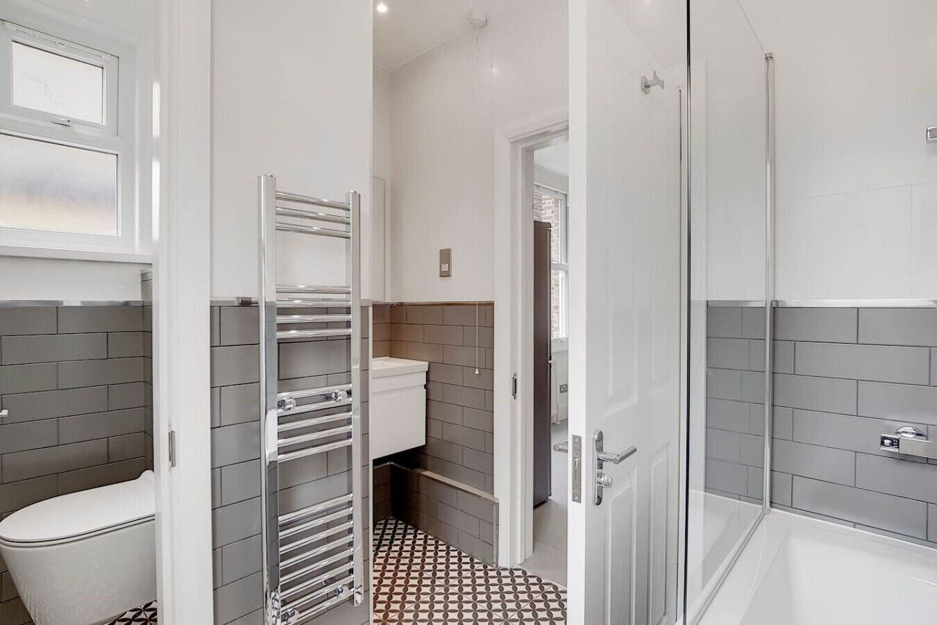 Een moderne badkamer met toilet, douche en wastafel.