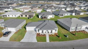 A residential area with multiple two-story houses, each with a front yard and driveway.