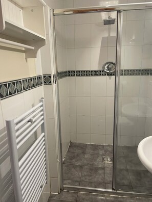 A shower with a glass door, tiled walls, and a white radiator. - Rooms at the Huntsman Inn (Falfield)