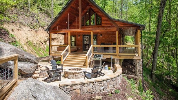 A wooden cabin with a stone foundation, a porch with outdoor seating, and a fireplace. - Brand New! Hickory Wind: Charming 2 Bedroom Cabin in Whittier (Whittier)