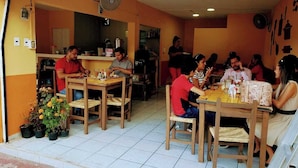 A restaurant with wooden tables and chairs, a tiled floor, and potted plants. - HOTEL HUMBERTO (Tepic)