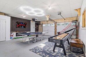 A room with ping pong tables, a pool table, and a TV displaying Netflix. - New! Pool/Hiking/Gym/Lake/Golf/karaoke/firepit/hot tub (Tobyhanna)