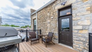 Un bâtiment en pierre avec une porte portant l’inscription « 404A LINCOLN » et une terrasse aménagée avec du mobilier d’extérieur.