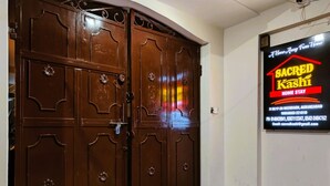 A brown wooden door with decorative handles and a sign advertising a home stay service.