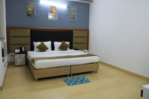 Ein Schlafzimmer mit einem hölzernen Bett, zwei Nachttischen, einem blauen Teppich mit Muster und Bildern an der Wand.