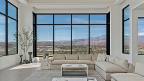 A spacious living room with a large sectional sofa, a coffee table, and a view of a mountainous landscape through floor-to-ceiling windows. - Zion Mountain / Pool, Hot Tub, BBQ & Pickleball (Washington)