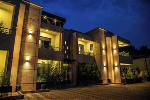 Stunning building with a symmetrical facade, featuring large windows and balconies, supported by vertical pillars.