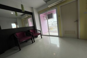A room with a red bench, a large mirror, and a sliding glass door leading outside. - Pongsatorn Mansion by Zuzu (Bangkok)