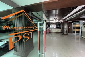 Un moderno vestíbulo de hotel con una recepción, divisiones de vidrio y un piso de baldosas limpias.
