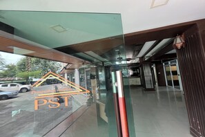 Un interior moderno con un separador de vidrio, un poste de metal y un techo de madera.