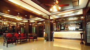 A lobby with a reception desk, seating area with sofas, and a polished floor. - Pongsatorn Mansion by Zuzu (Bangkok)