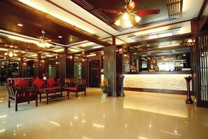 A lobby with a reception desk, seating area with sofas, and a polished floor. - Pongsatorn Mansion by Zuzu (Bangkok)