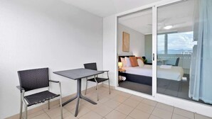 Una habitación pequeña con una cama, una mesa y dos sillas.