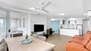 Una sala de estar moderna con comedor, cocina y zona de estar con sillones de masaje.