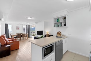 Un appartamento moderno con cucina, zona pranzo e soggiorno.