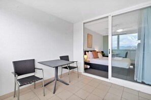 Une pièce comprenant un lit, une table et deux chaises.