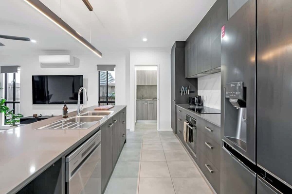 Create effortless meals in a chic kitchen with sleek black cabinetry, modern appliances, and a spacious island perfect for prepping, plating, or simply chatting over coffee.