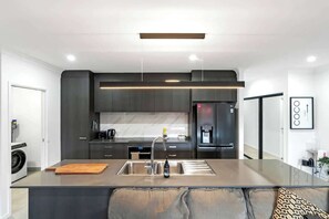 A modern kitchen with a central island, built-in appliances, and a minimalist design.