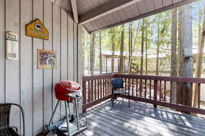 Enjoy outdoor cooking and dining on the deck, surrounded by a tranquil forest setting.
