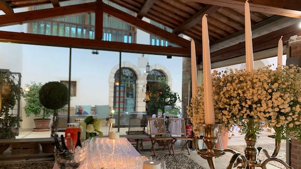 A covered outdoor seating area with tables, chairs, and a decorative flower arrangement. - Villa Valmarana De Toni-Dimora Storica (Creazzo)