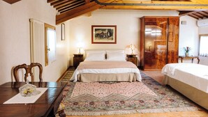A bedroom with a bed, a nightstand, a wooden wardrobe, a mirror, and a patterned rug. - Villa Valmarana De Toni-Dimora Storica (Creazzo)