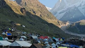 A campsite with multiple tents set up on a rocky terrain, surrounded by mountains. - Neelkanth camp Kedarnath (Kedarnath)
