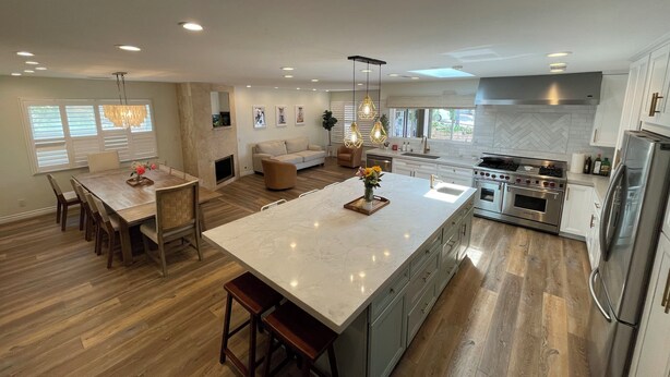 A modern kitchen with a large island, wooden flooring, and stainless steel appliances. - Resort-Style Home for Families: Pool, Theater, Arcade, Hot Tub, Central location (San Diego)