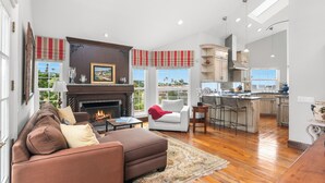 A spacious living room with a fireplace, a sofa, and a view of the city.
