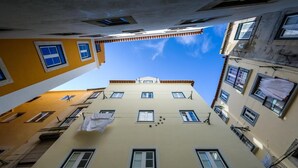 Una calle estrecha flanqueada por edificios con numerosas ventanas y balcones.