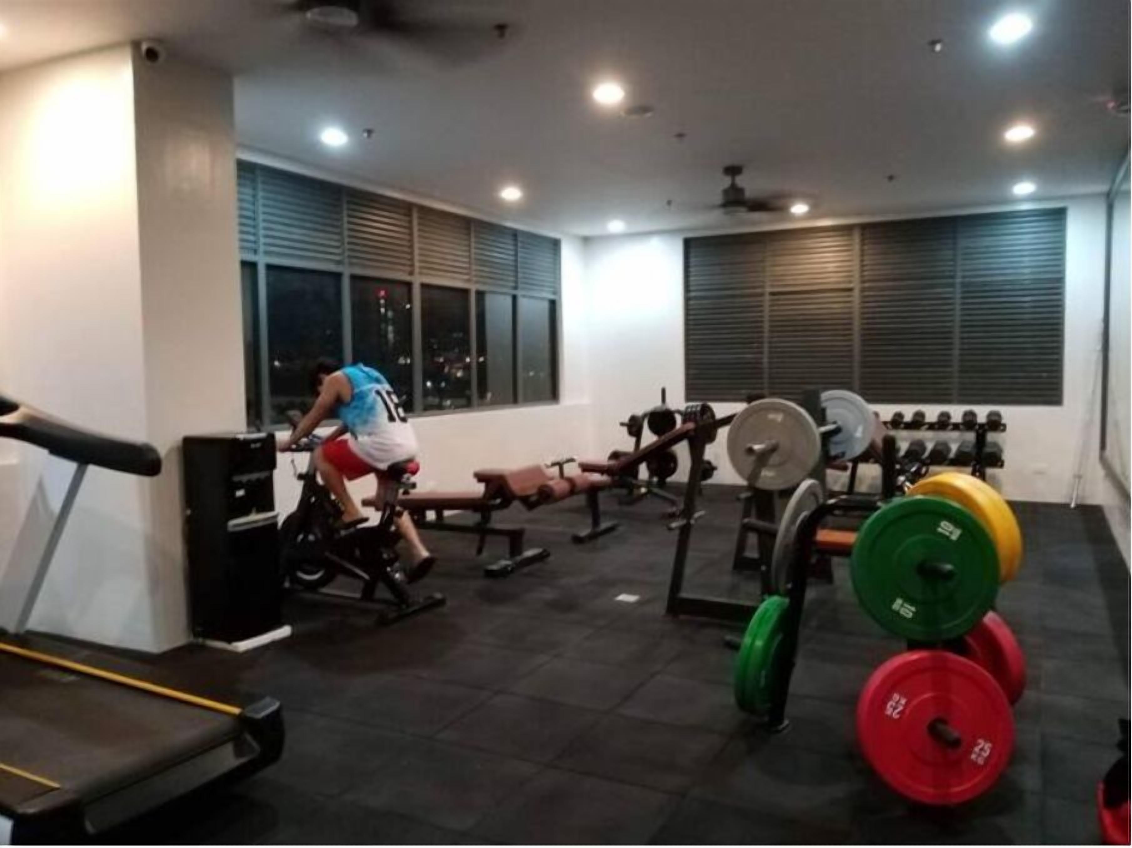 Une salle de sport équipée de matériel d’exercice, d’un tapis de course et de stations d’entraînement avec des poids.