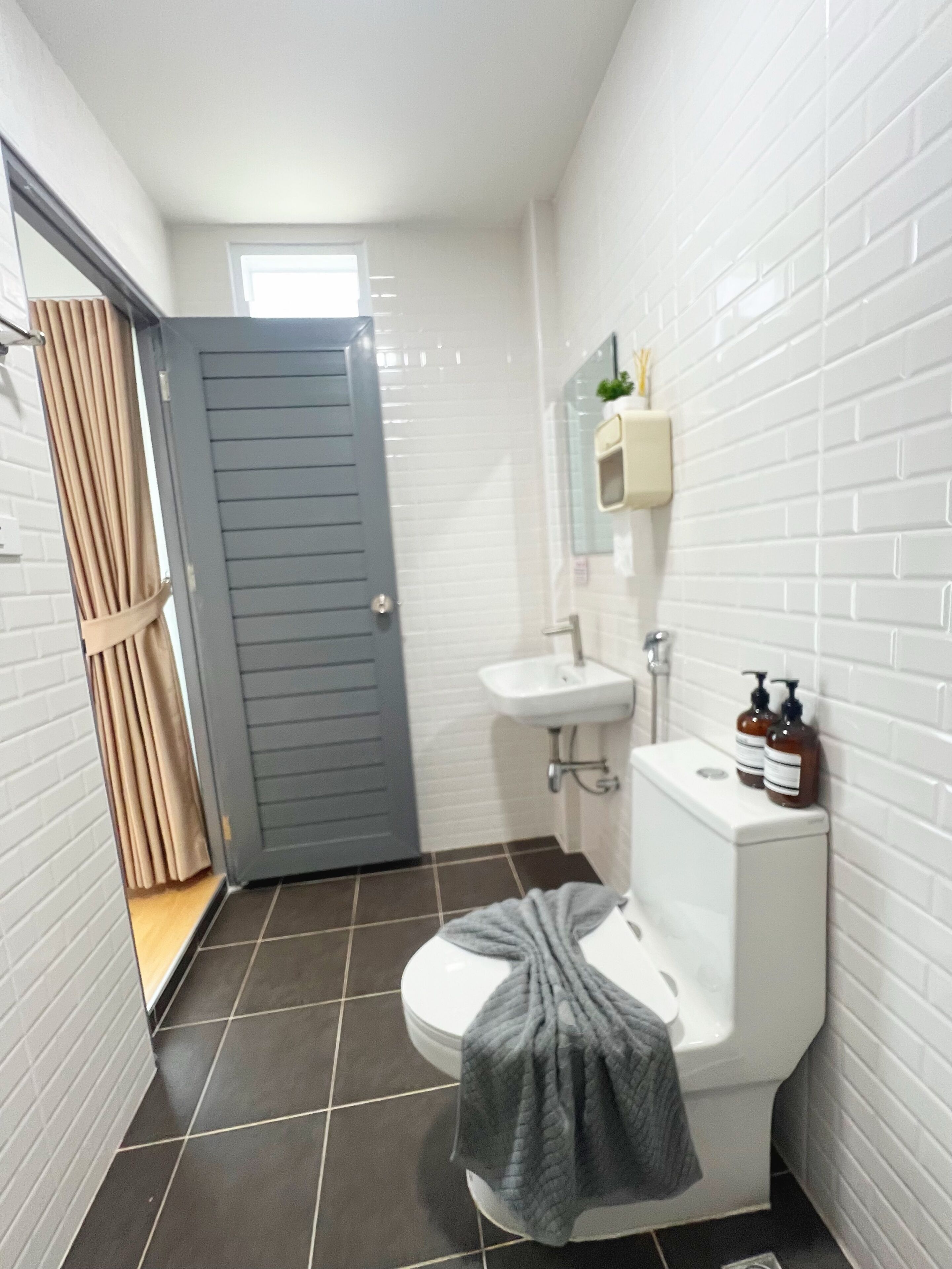 A small bathroom with a toilet, sink, and mirror.