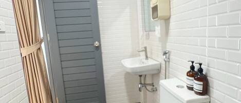 A small bathroom with a toilet, sink, and mirror.