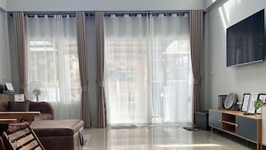 Ein geräumiges Wohnzimmer mit einem großen Flachbildfernseher, einer Couch, einem Couchtisch und einer Holzbank.